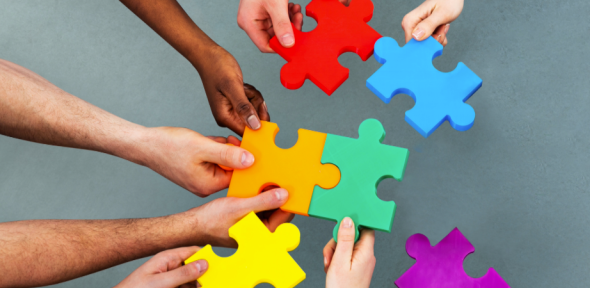 Photo of hands holding jigsaw pieces Photo of hands holding jigsaw pieces