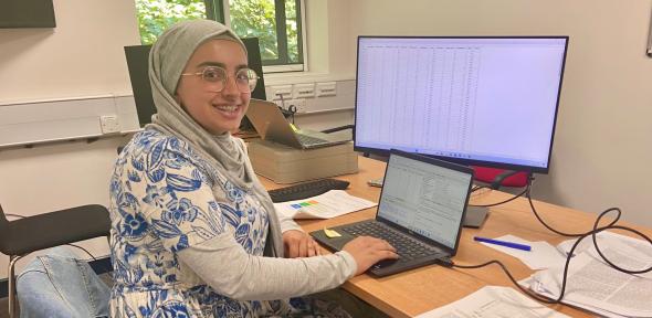 Photo of 2024 Nuffield Placement Student, Zayneb Kasur Photo of 2024 Nuffield Placement Student, Zayneb Kasur, sat at desk in front of computer screen